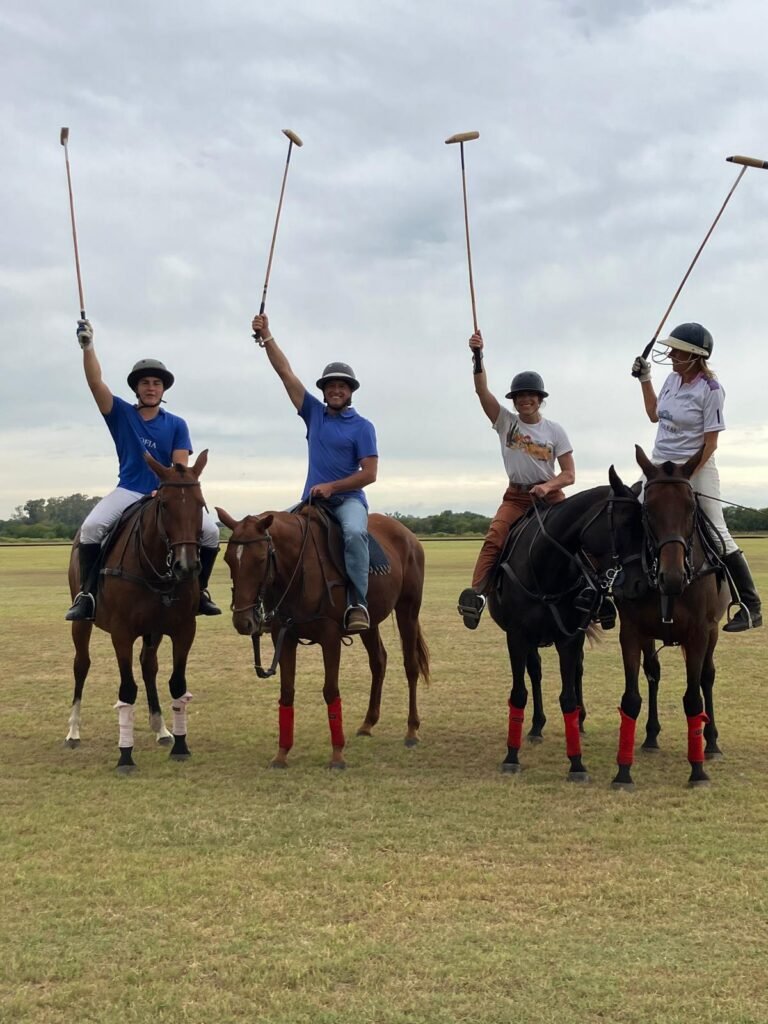 Four polo players posed on their horses