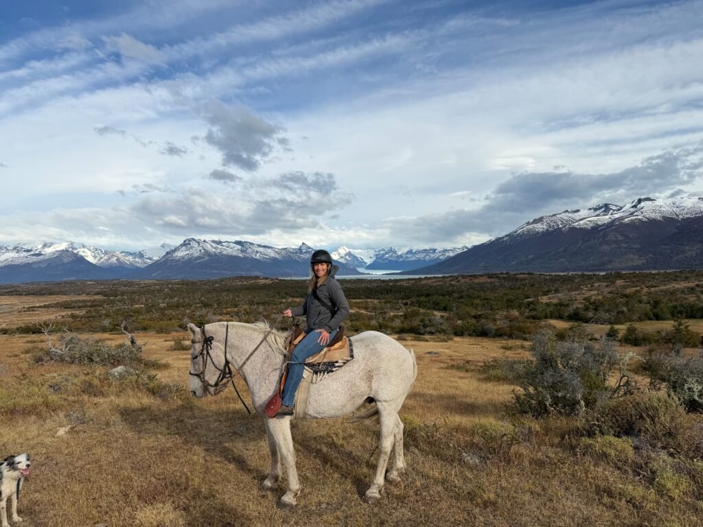Mrs Bader posing on a horse in Patagonia with mountains in the background