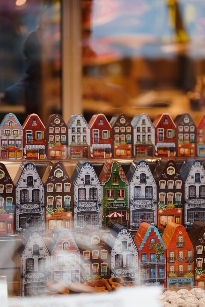 christmas house decorations on display behind a shop window